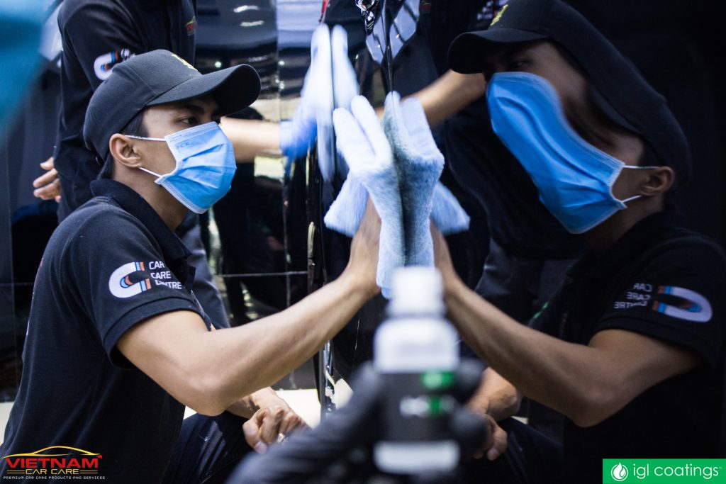 nhân viên vietnam car care đang lau chiếc xe màu đen