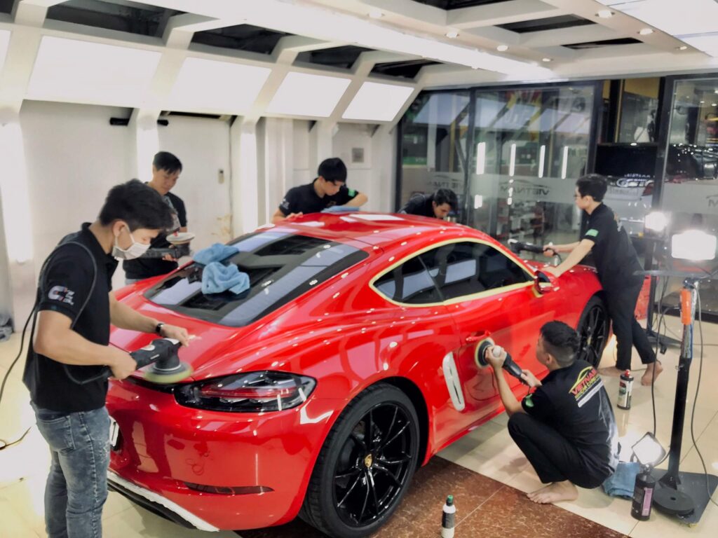 nhan vien vietnam car care dang danh bong chiec xe mau do